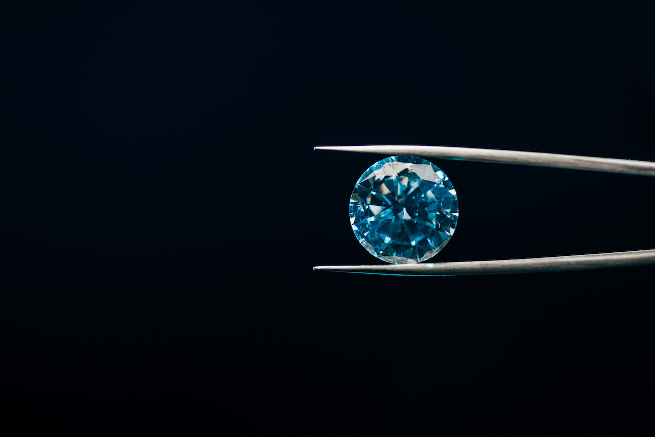 non-conflict diamond in blue hue held in tweezers non-conflict diamond in blue hue held in tweezers