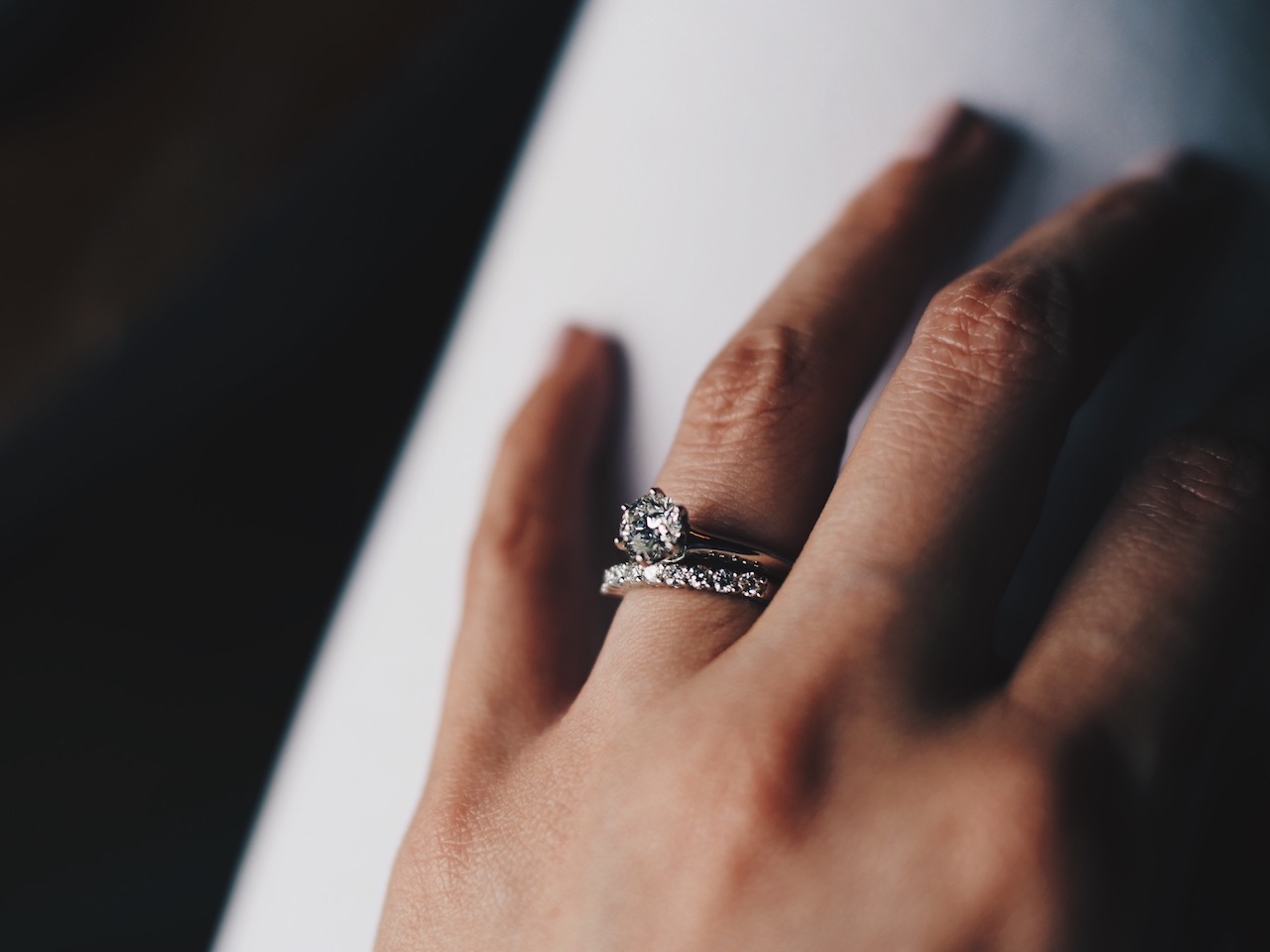 Close up of wedding band and engagement ring woman wearing both wedding band and engagement ring