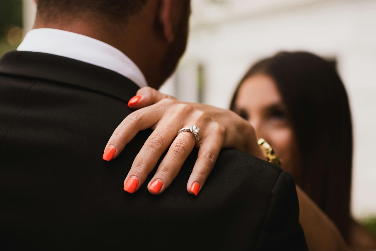 A close-up of a bride-to-be dancing with her groom, with emphasis on her diamond engagement ring. A close-up of a bride-to-be dancing with her groom, with emphasis on her diamond engagement ring.